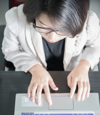 Young asian woman short hair in smart casual wear working on laptop in home office